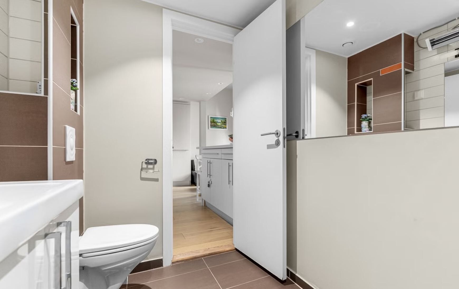 Ein modernes Badezimmer mit Toilette, Waschbecken und Duschbereich.