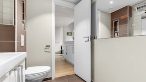 Ein modernes Badezimmer mit Toilette, Waschbecken und Duschbereich.