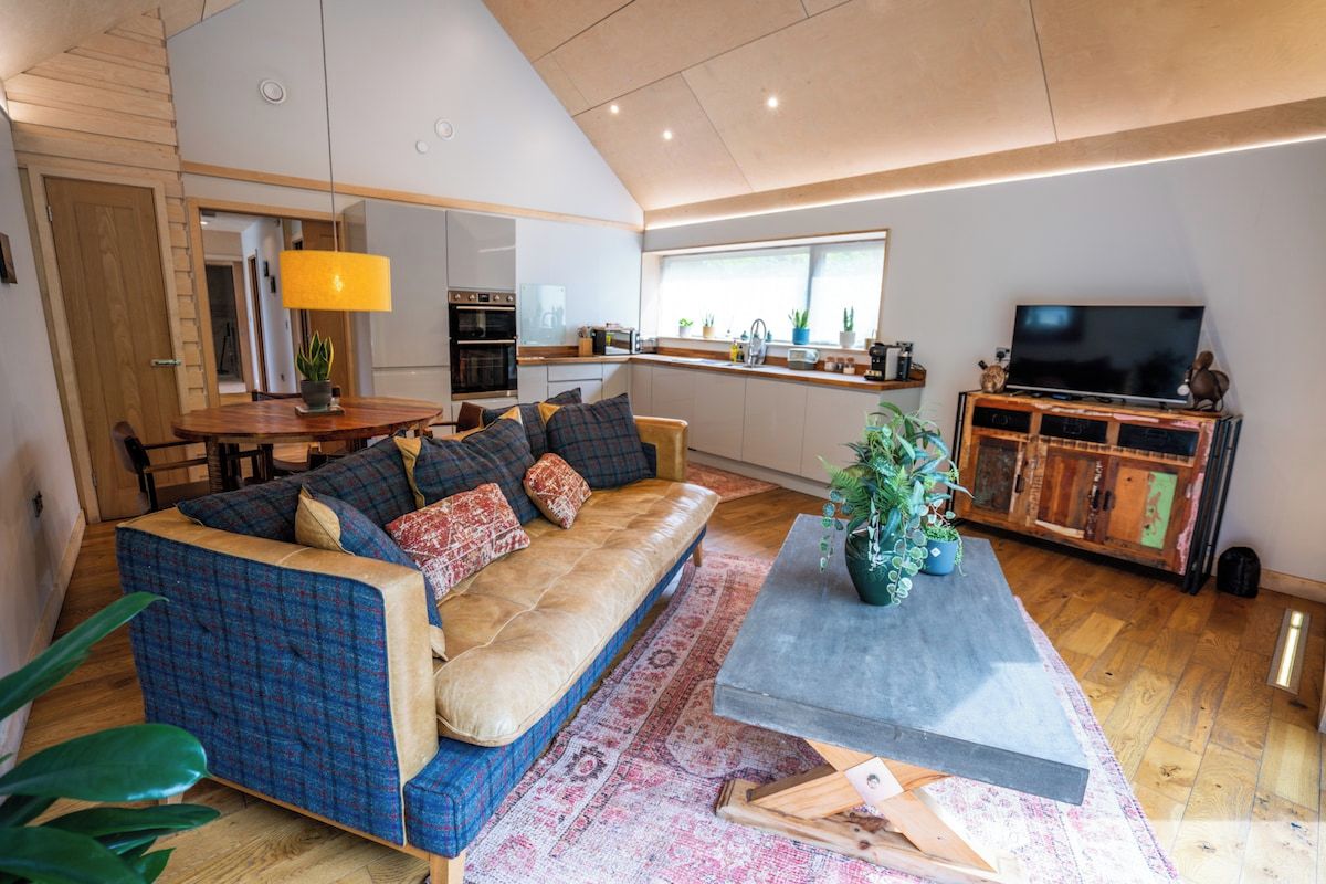 Una sala de estar moderna con sofá, mesa de centro y televisor.