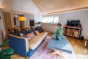 A modern living room with a sofa, coffee table, and a television.