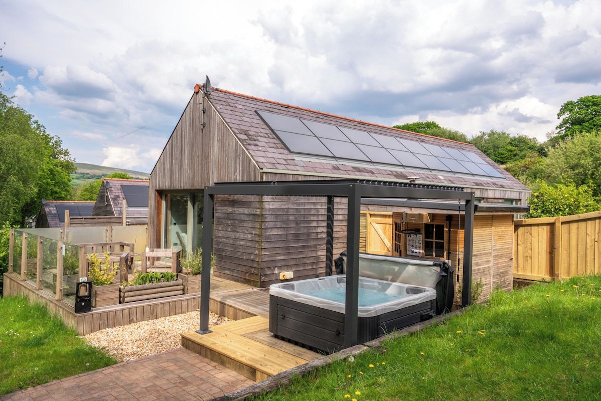 A wooden house with a hot tub and a covered patio area.