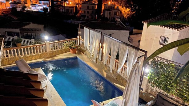 Une piscine sur le toit offrant une vue dégagée sur le paysage urbain la nuit.