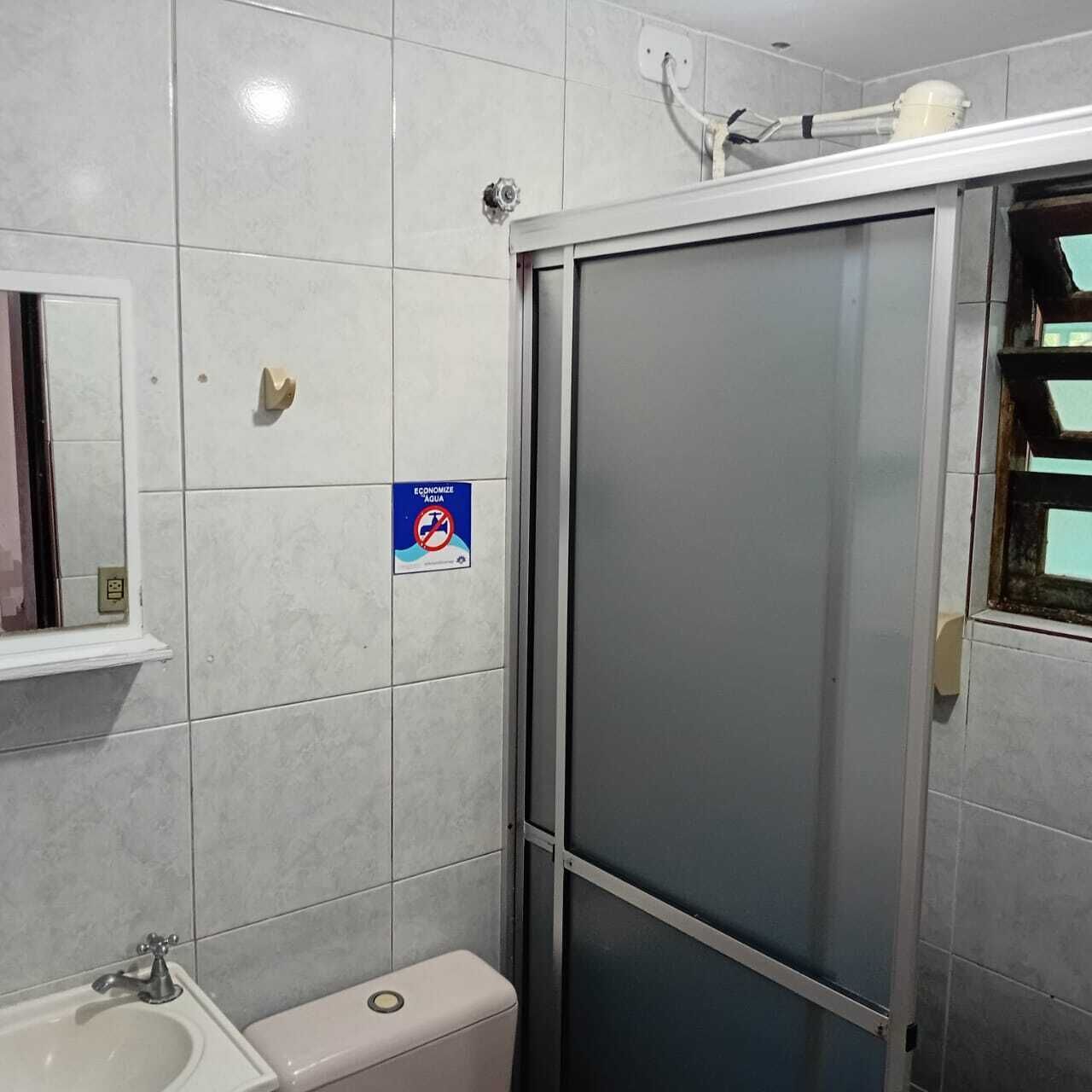 A bathroom with a toilet, sink, and a shower area.