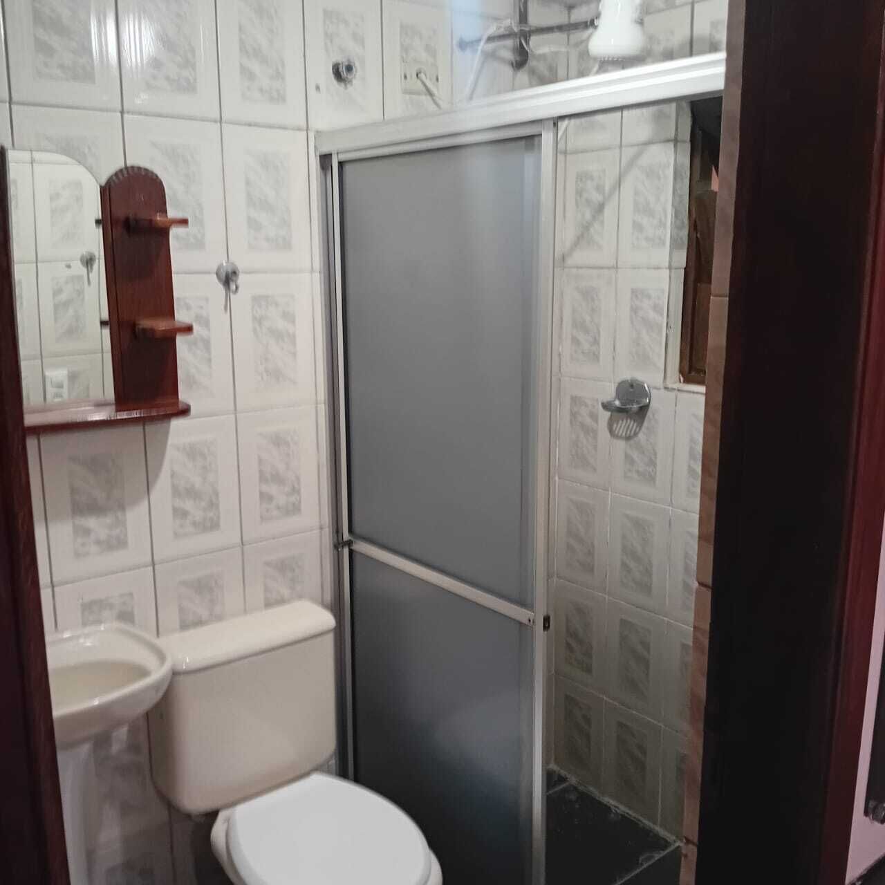 Un baño con inodoro, lavamanos y cabina de ducha.