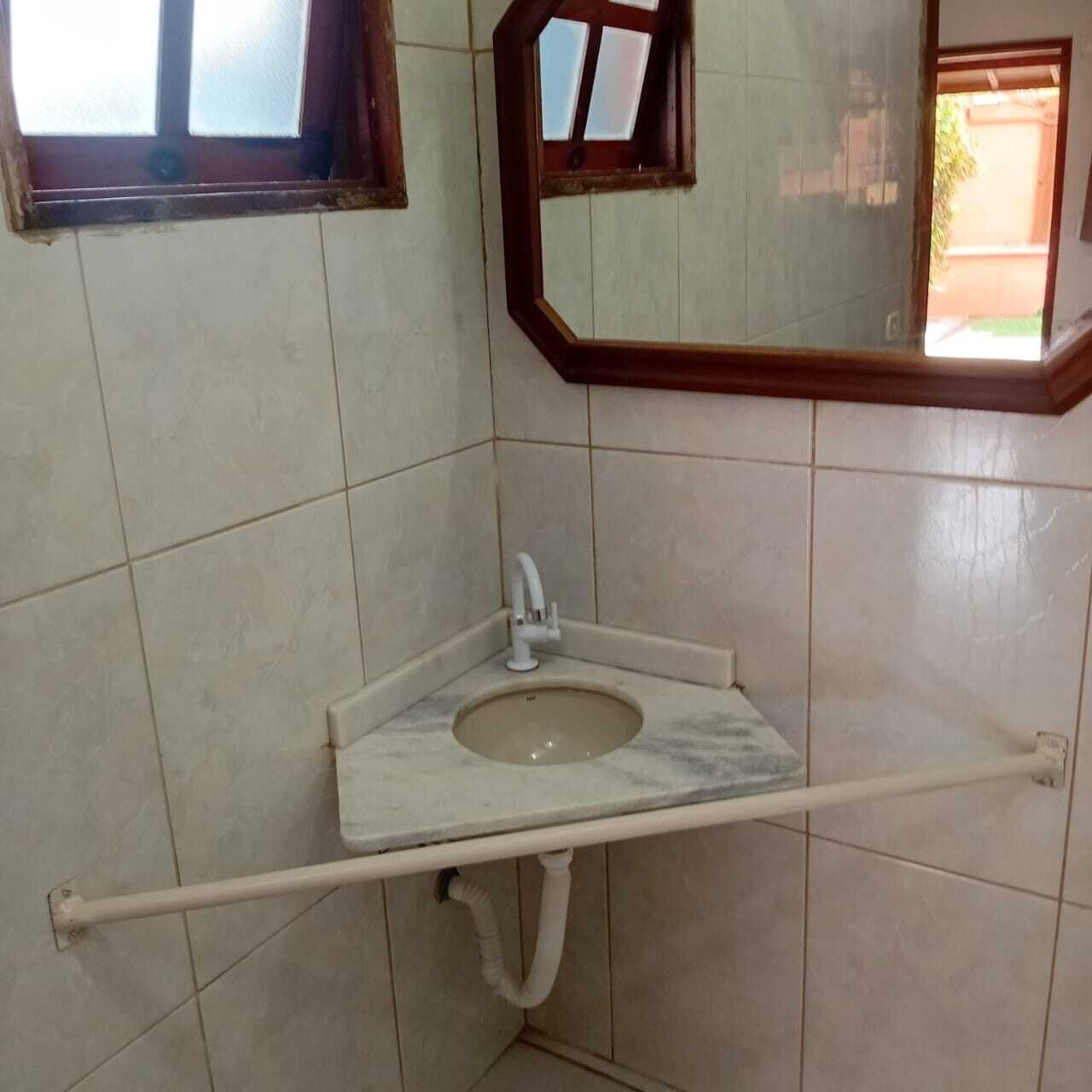 A bathroom with a marble sink, a mirror, and a window.