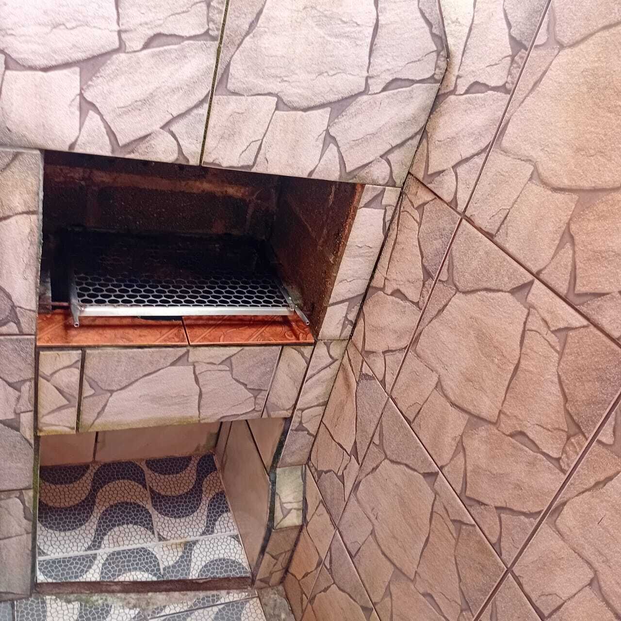 A stone wall with a metal grill opening.