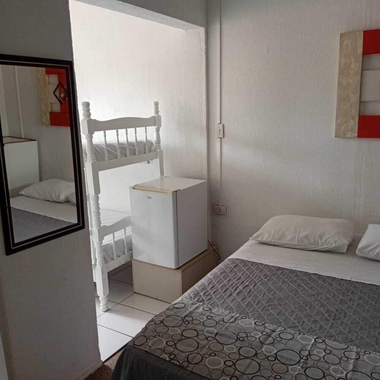 Ein Schlafzimmer mit einem Bett, einem kleinen weißen Schreibtisch und einem weißen Stuhl.
