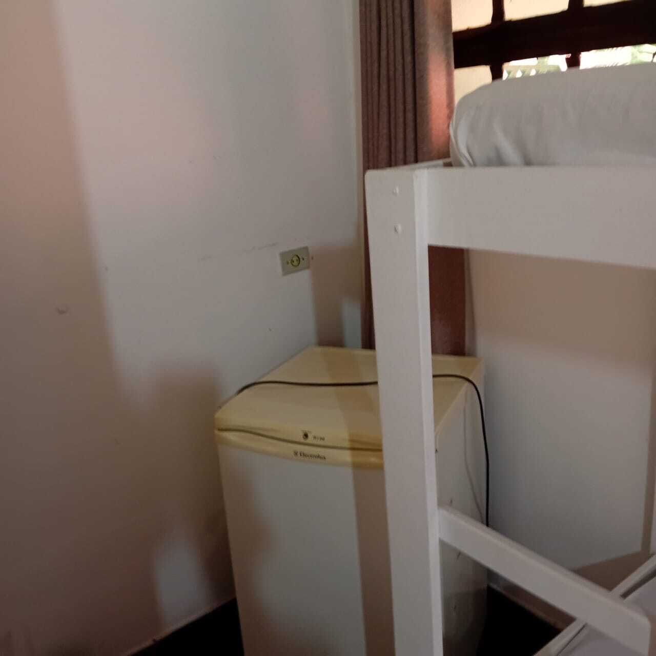 A bunk bed with a mattress and a small bedside table.