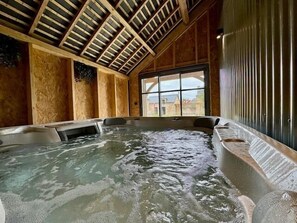 A hot tub with a wooden ceiling and large windows. - Lys'toire - Grand Jardin (Dinan)