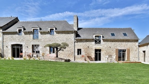 A stone building with a large lawn in front.