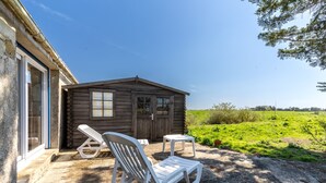 A wooden cabin with two white lounge chairs and a small table outside. - L’Échappée du Port - Grand Jardin (Bouin)