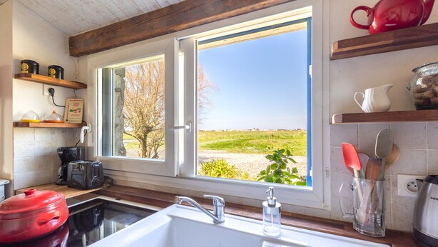 A kitchen with a large window, a sink, and various kitchen appliances. - L’Échappée du Port - Grand Jardin (Bouin)