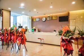 A hotel reception area with a reception desk, chairs, and potted plants. - Crown Boutique Hotel (Sertar)