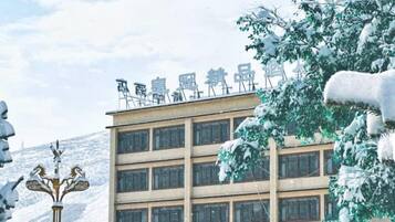 Un edificio de varios pisos con un letrero en el techo.