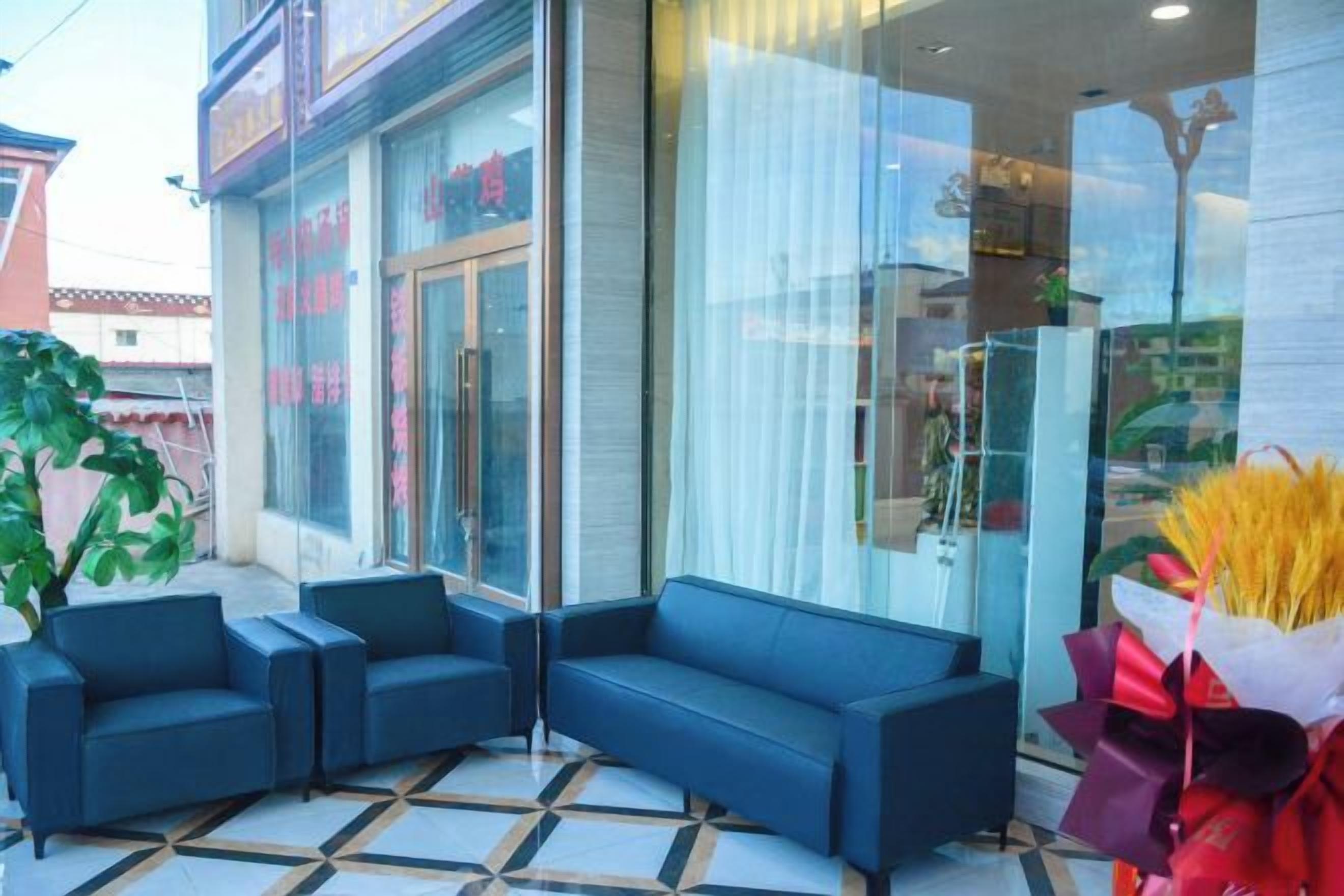 A hotel lobby with a seating area, a glass storefront, and a tiled floor.