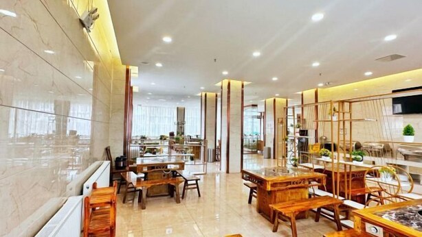 A spacious hotel lobby with wooden furniture, a marble floor, and a large mirror reflecting the interior. - Crown Boutique Hotel (Sertar)