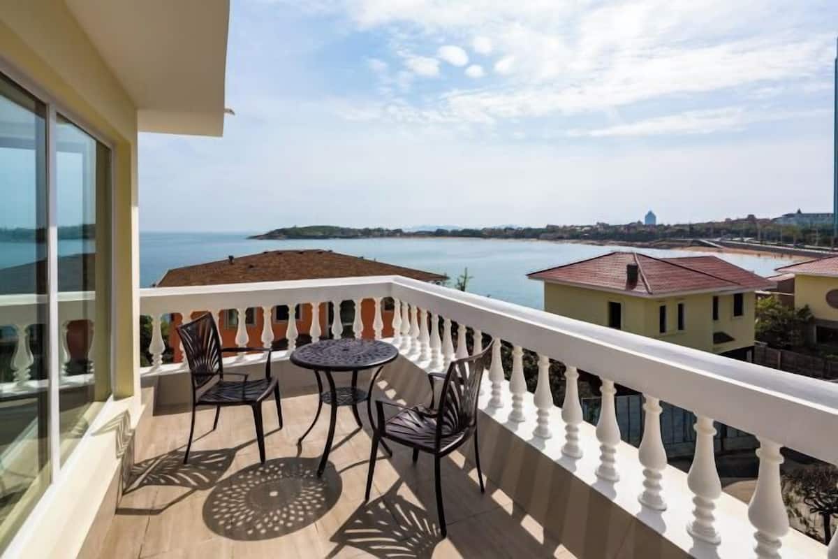 Ein Balkon mit Blick auf das Meer und eine entfernte Insel.