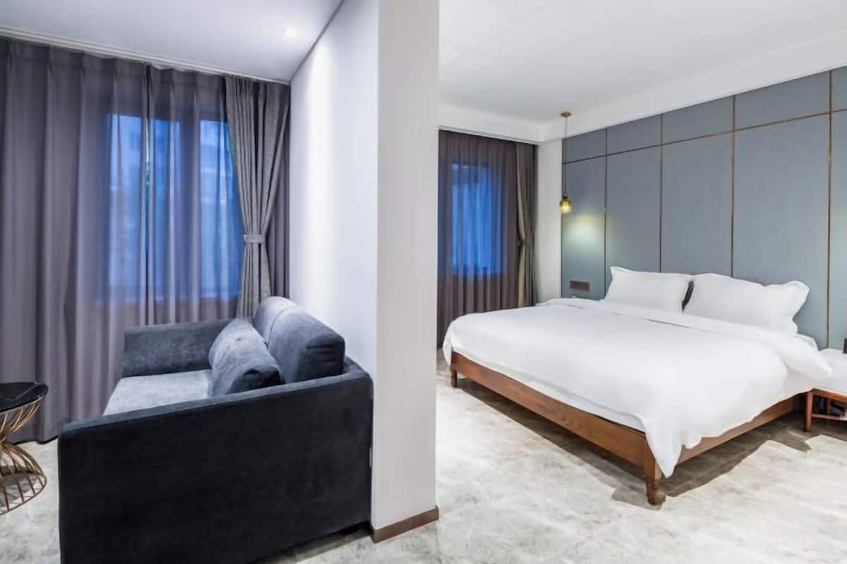 Ein modernes Hotelzimmer mit einem großen Bett, einer Schlafcouch und einem kleinen Tisch.