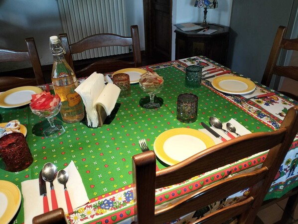 A dining table set with plates, cutlery, and a bottle of wine. - Villa Road, Sibillini Mountains (Serra)