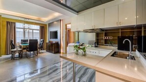 Una cocina moderna con armarios blancos, encimera de mármol y estufa empotrada.