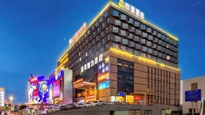 Un hotel de varios pisos con señalización iluminada y una entrada destacada.