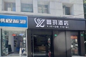 Entrada de un hotel con un letrero que dice 'Xinyub Hotel'.