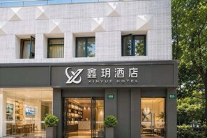 A hotel with a modern facade, large windows, and a visible reception area. - Manzhiya Theme Hotel (Shanghai Wanhangdu Road) (Shanghai)
