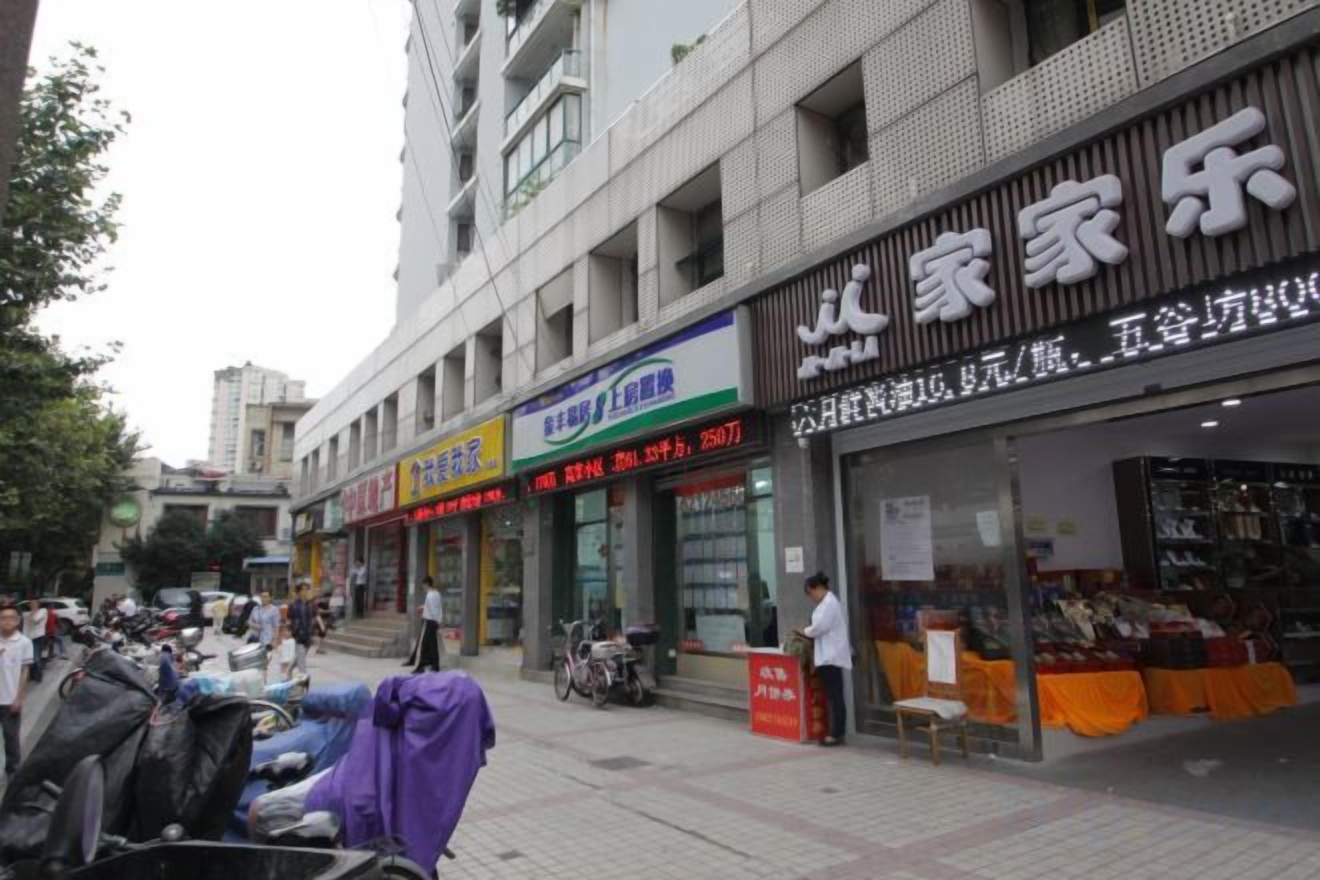 Una calle con diversos comercios, incluyendo una tienda de ropa y un centro de entretenimiento familiar.
