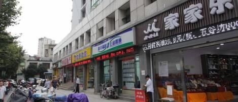 Una calle con diversos comercios, incluyendo una tienda de ropa y un centro de entretenimiento familiar.