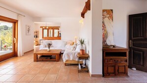 Ein gemütliches Wohnzimmer mit einer Couch, einem Couchtisch und einem Hund. Es gibt einen Holzschrank und ein Bild an der Wand.