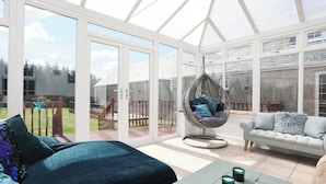 A conservatory with a glass ceiling, a hanging chair, a sofa, and a bed. - Greenknowes Entire Private Estate (Blairadam)