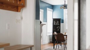 A hallway leading to a dining area with a chandelier, wooden shelves, and a fireplace. - 2-bedroom apartment in Portland, ME with WiFi, AC. Enjoy your stay! (Portland)