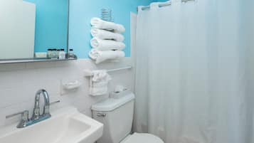 Tina con regadera, toallas, papel de baño