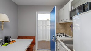 A compact kitchen with a stove, microwave, and refrigerator. - The Beach House at Drifting Sands (Beach Haven)