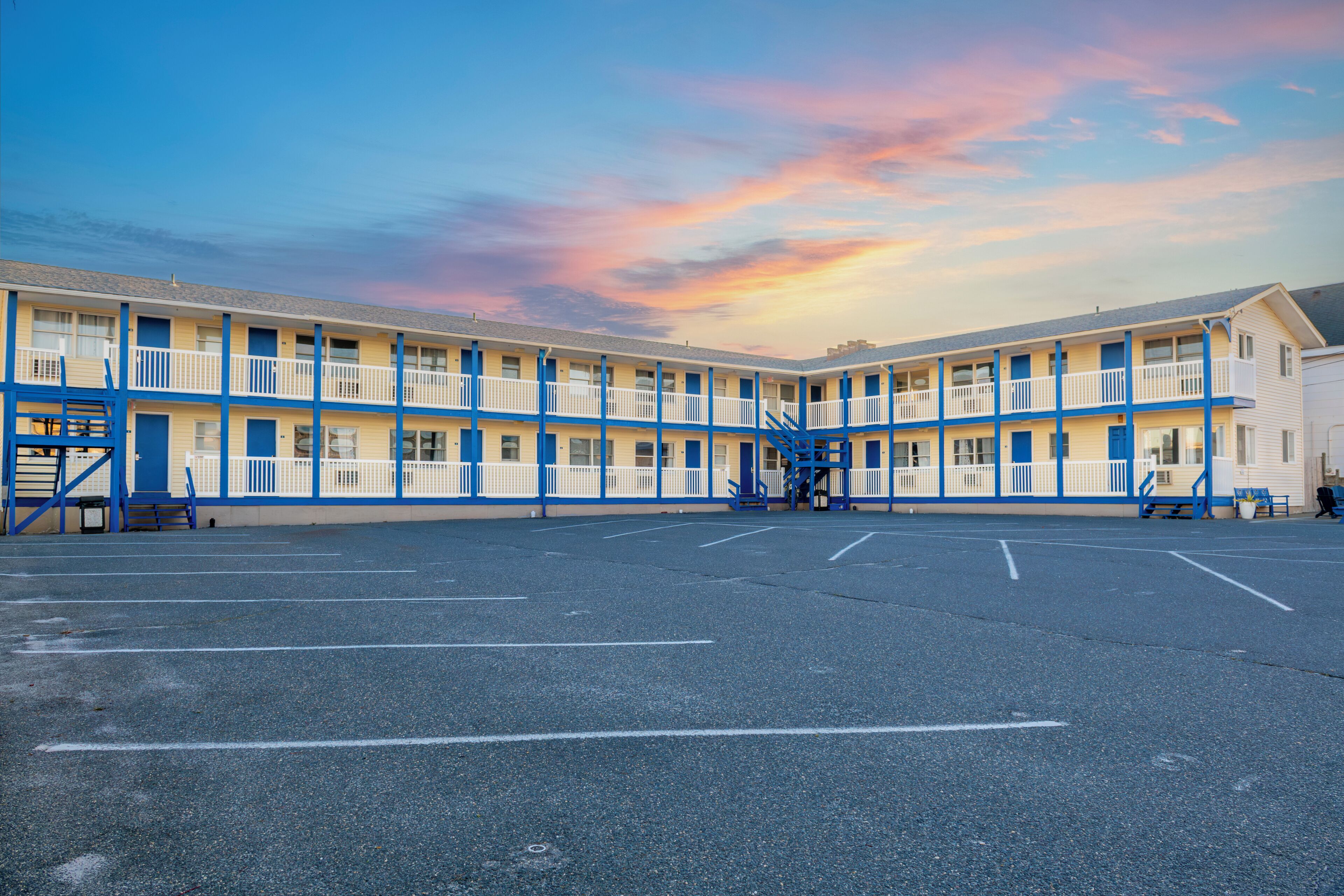 Ein Motel mit Innenhof, mehreren Balkonen und Parkplatz.