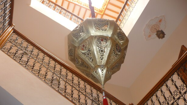 A staircase with ornate metal railings and a decorative hanging light fixture. - MARRAKECH RYAD ALL COMFORTS IN A RESIDENCE WITH 3 LARGE SWIMMING POOLS (Marrakech)