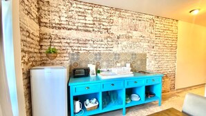 A kitchen with a brick wall, a blue countertop, and a white refrigerator. - Furlong1 Apartment in down Town city near the malecón and restaurants (La Paz)