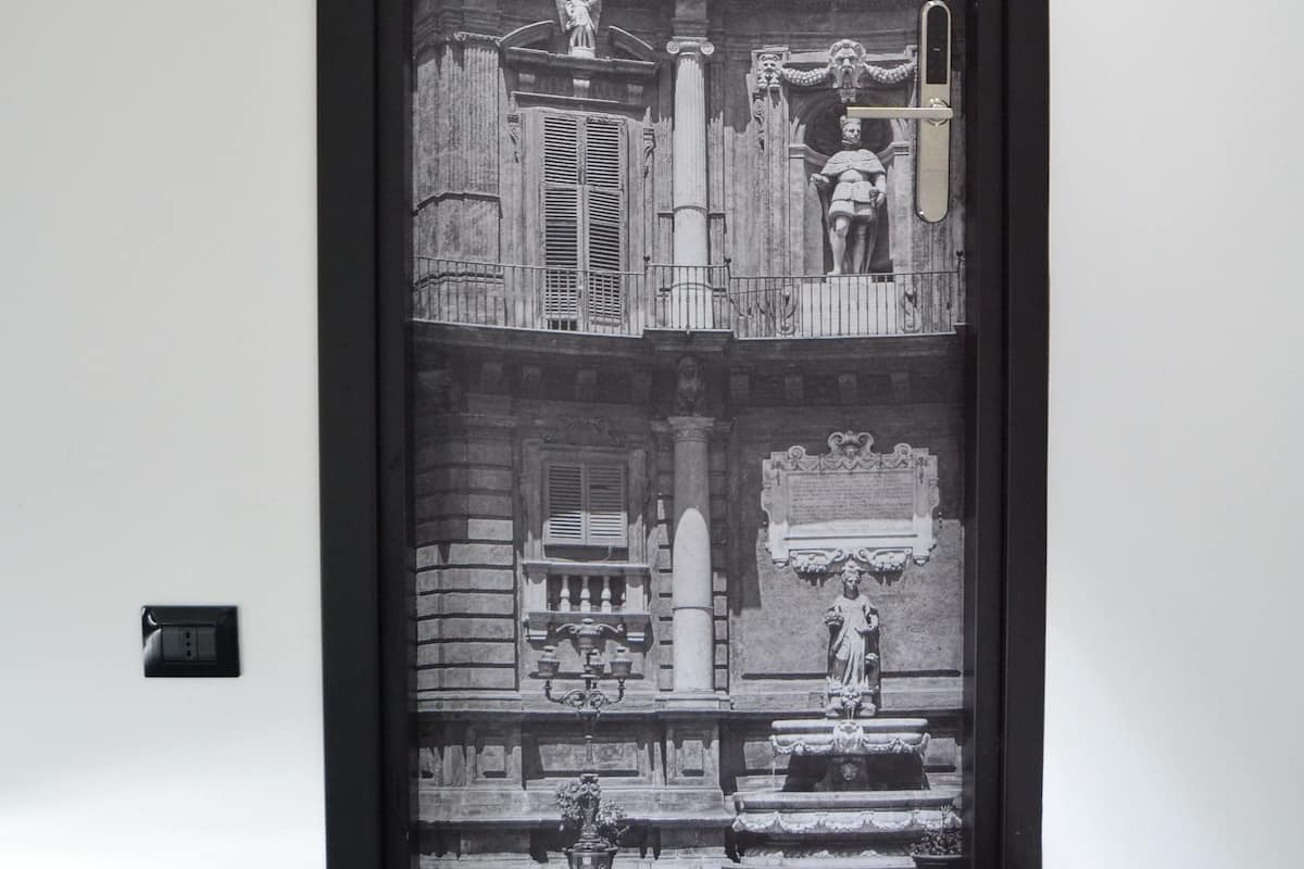 A framed black and white photograph of a building facade with statues and architectural details.