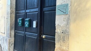 A dark wooden door with a brass handle, a mailbox, and a sign with a map outline.