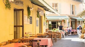 An outdoor café with tables and chairs, a sign reading "COMPTOIR," and a restaurant named "CHEZ JULES" in the background. - Comfortable apartment in the heart of Antibes (Antibes)