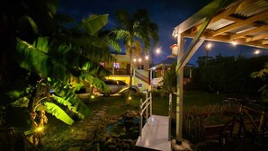 A nighttime view of a house with a wooden deck, a hammock, and a bicycle. - Genesis King Suite Apt 4 located in peaceful valley AC, Wi-Fi, King Bed (Cassada Gardens)
