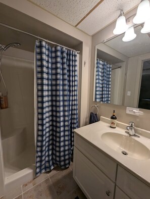 Chuveiro, toalhas de banho, sabonete, papel higiênico