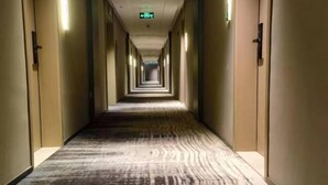A long, narrow hotel corridor with carpeted floors and doors on both sides. - Shishi Live DNG Hotel (Shishi)