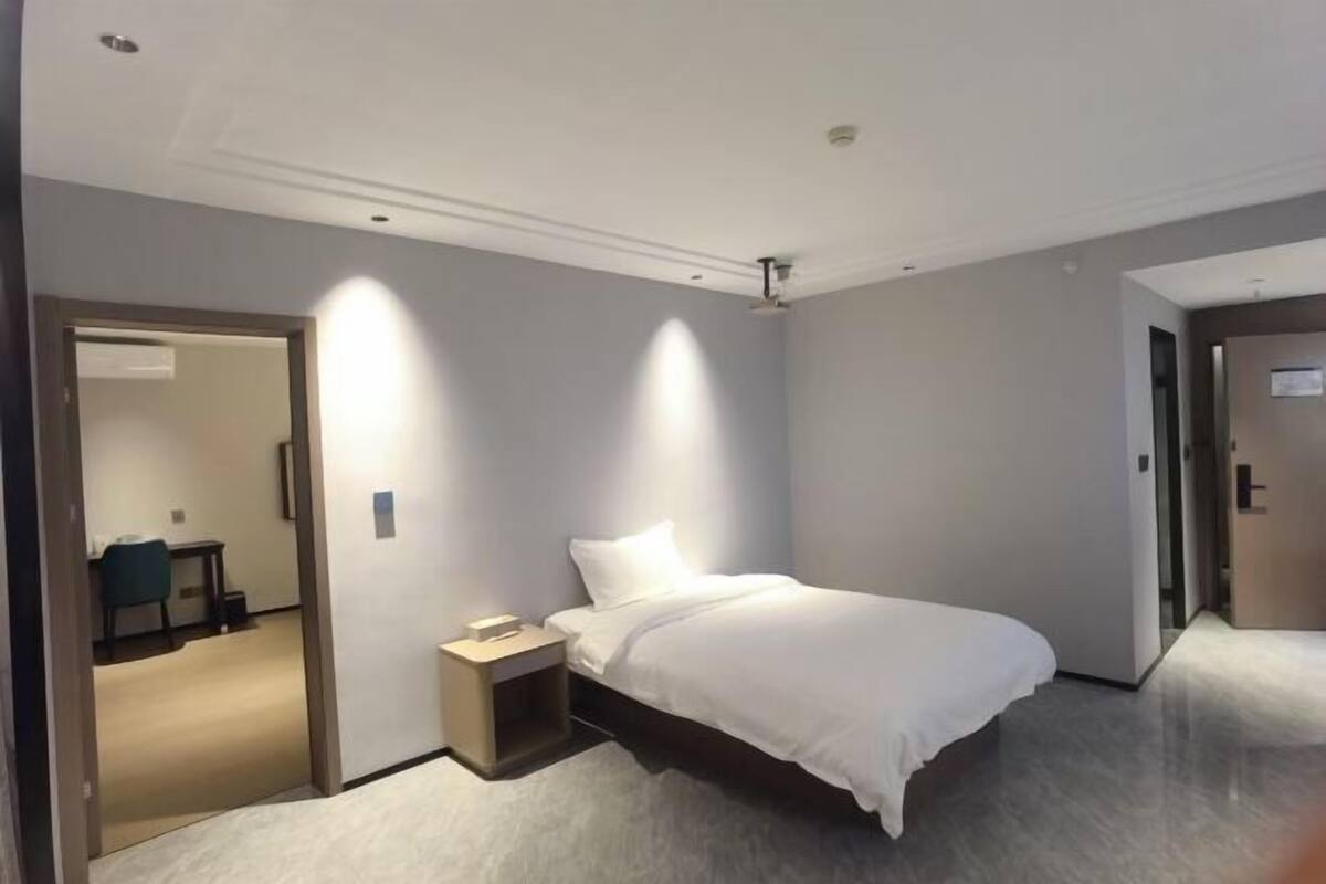 Ein Hotelzimmer mit Bett, Nachttisch und Spiegel.