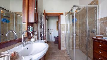 A bathroom with a double sink, a shower enclosure, and a wooden vanity.