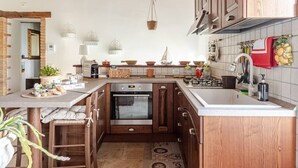 A kitchen with wooden cabinets, a built-in oven, and a countertop with various kitchen items.