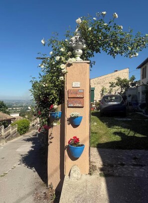 Ein Gebäude mit einer Steinfassade, einem Schild mit der Nummer 20 und Blumentöpfen.