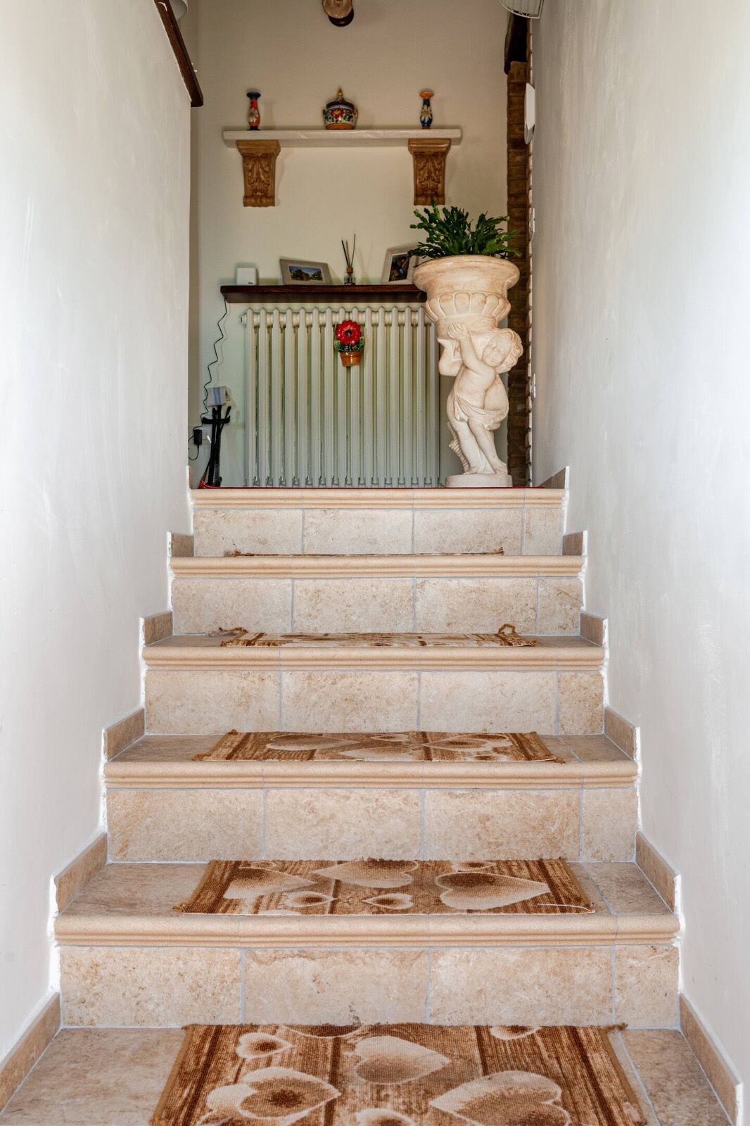 A staircase with beige tiles and a decorative pattern at the bottom.