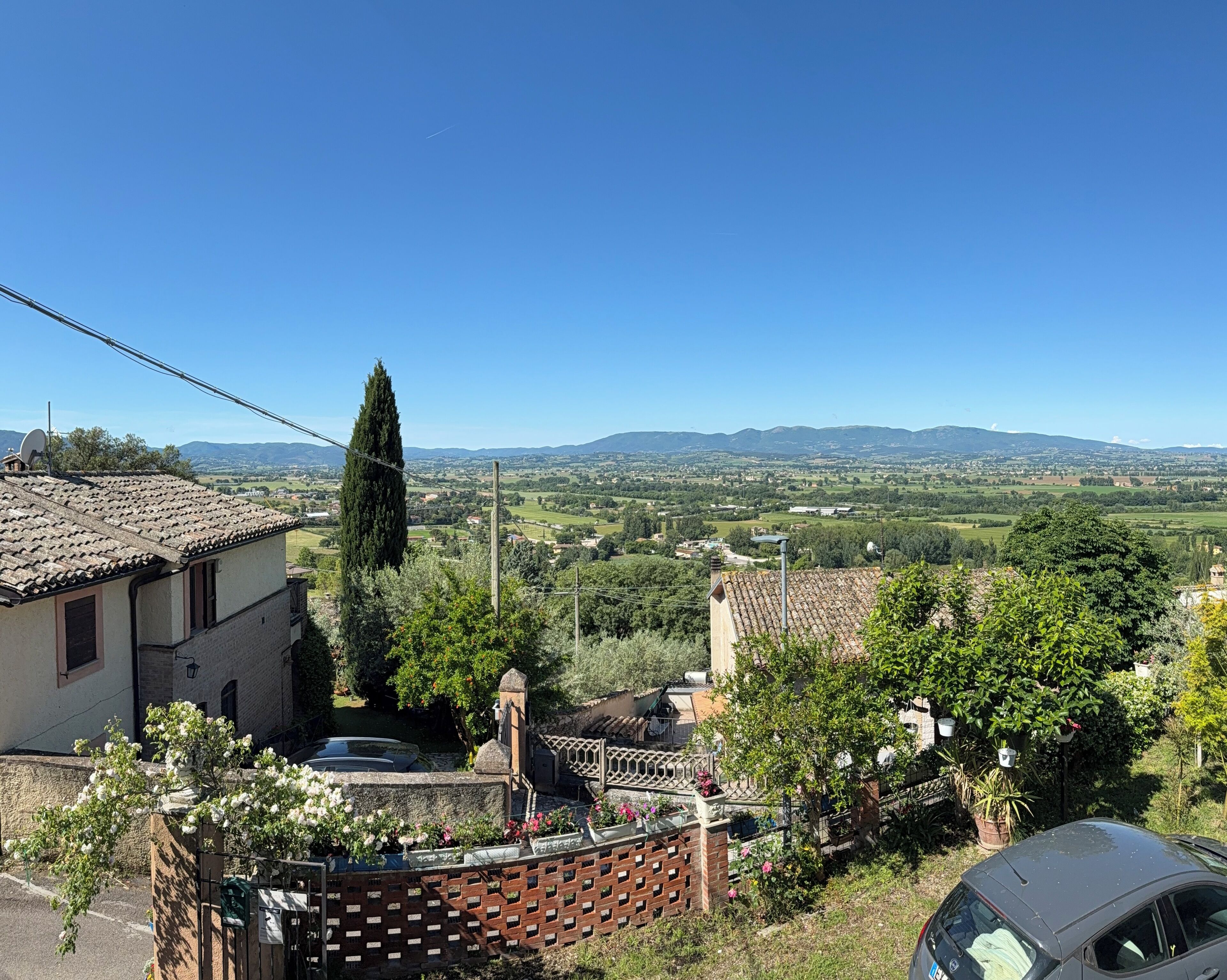 A residential area with a view of distant hills and a clear sky.