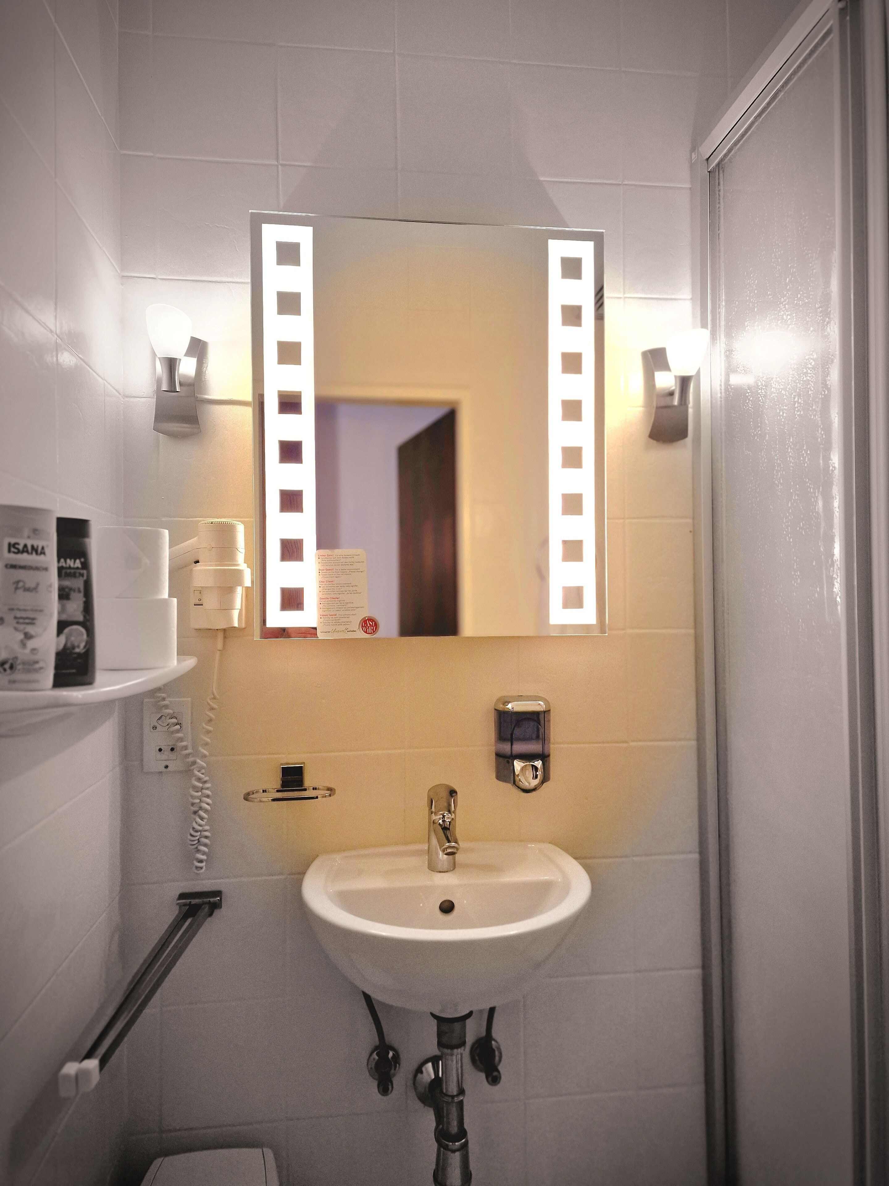 A bathroom with a sink, mirror, and towel rack.